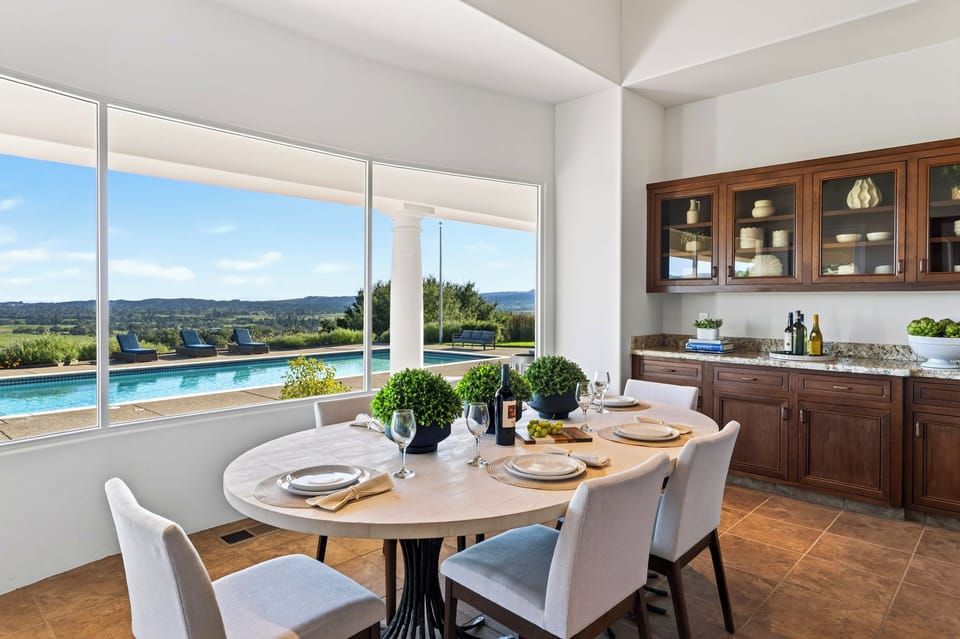 Breakfast with a view, the dining table looks straight over the pool to the hills.