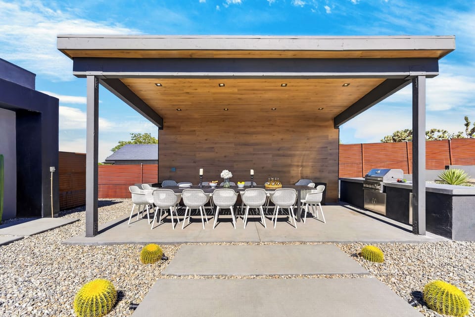 Shaded dining pavilion with seating for a crowd and a built-in grill for desert cookouts.