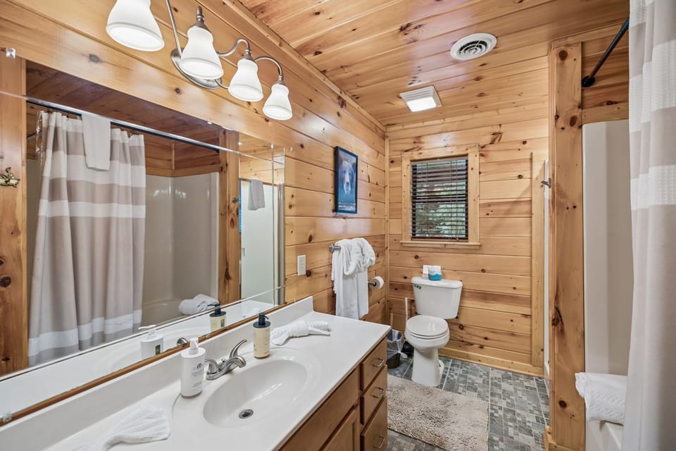 Bathroom 1: A clean and comfortable full bathroom with everything needed to refresh and recharge, offering a practical and relaxing space during your cabin stay.