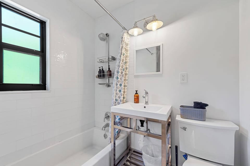 Clean, modern full bathroom with walk-in tile shower and vanity