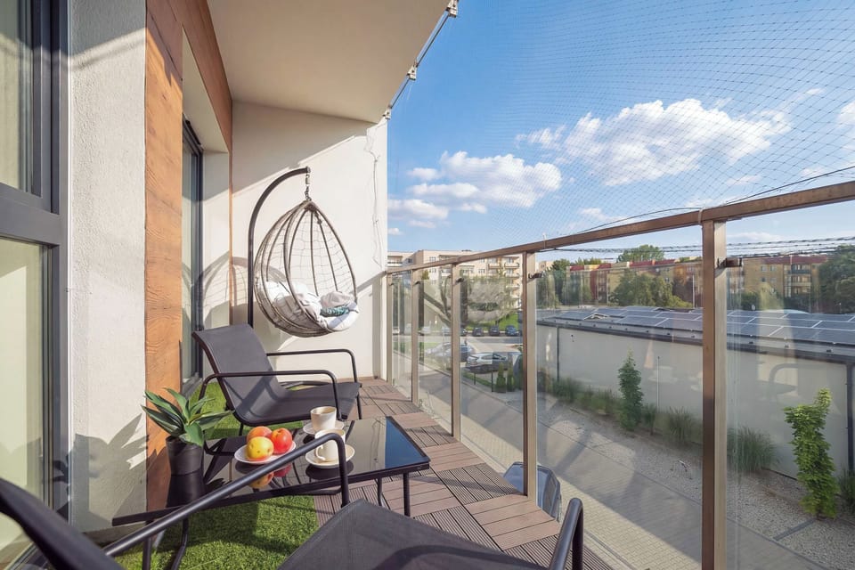 The balcony has a hanging chair with cushions where someone can sit and relax.