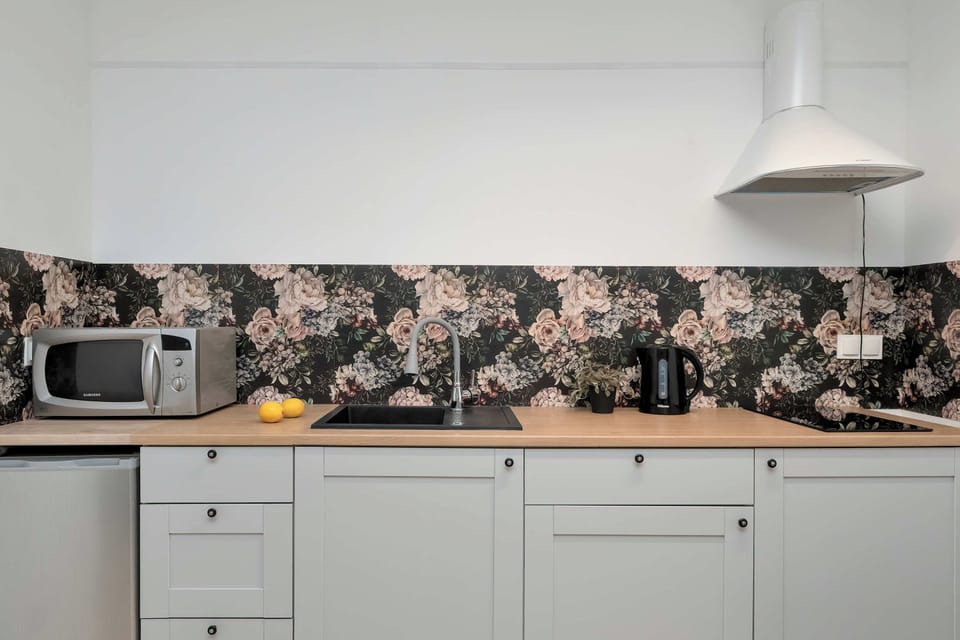 The kitchenette is equipped with modern light grey cabinets and a wooden countertop.