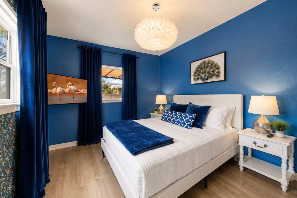 Stylish blue bedroom with plush queen bed and elegant lighting