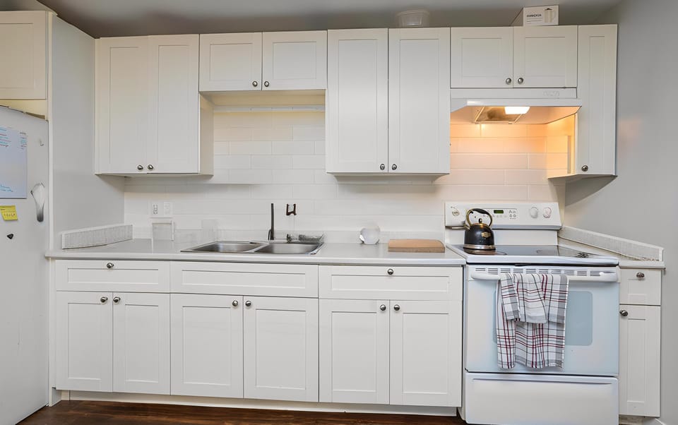 Main kitchen setup complete with a double sink, gas range, and plenty of cabinet storage for long-term stays.