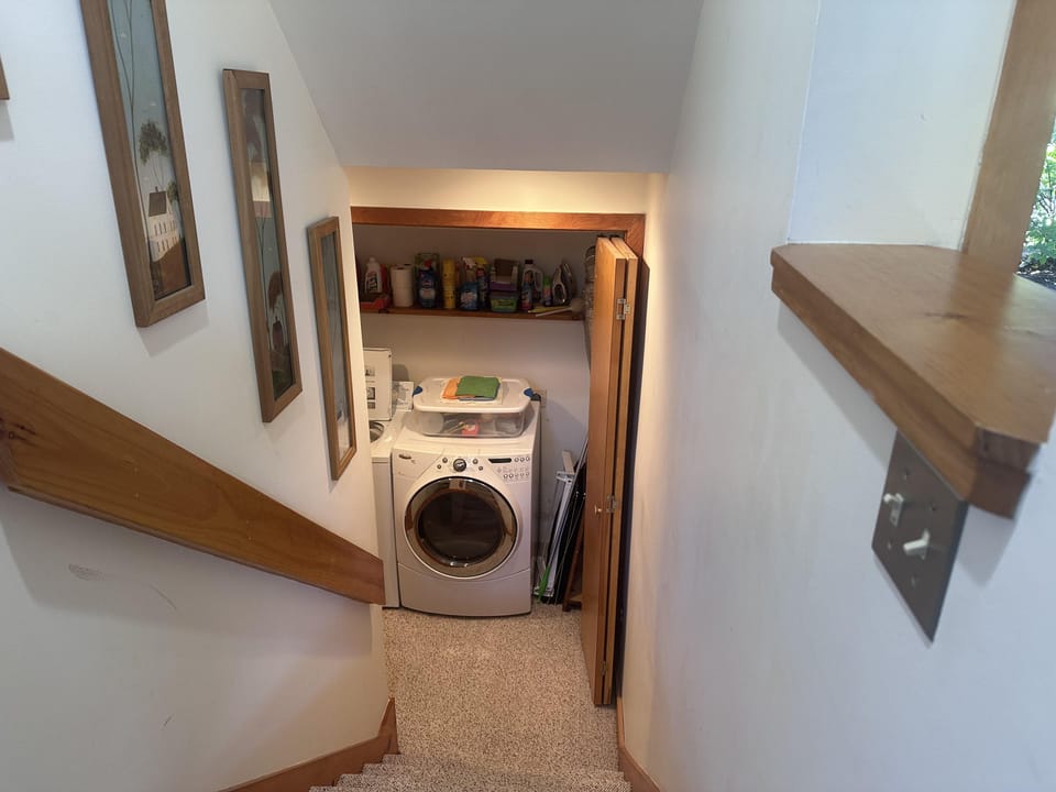Compact laundry nook with white front-loading washer and dryer.