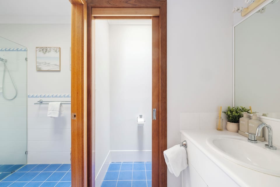 Bright coastal-style bathroom with spacious vanity and separate shower