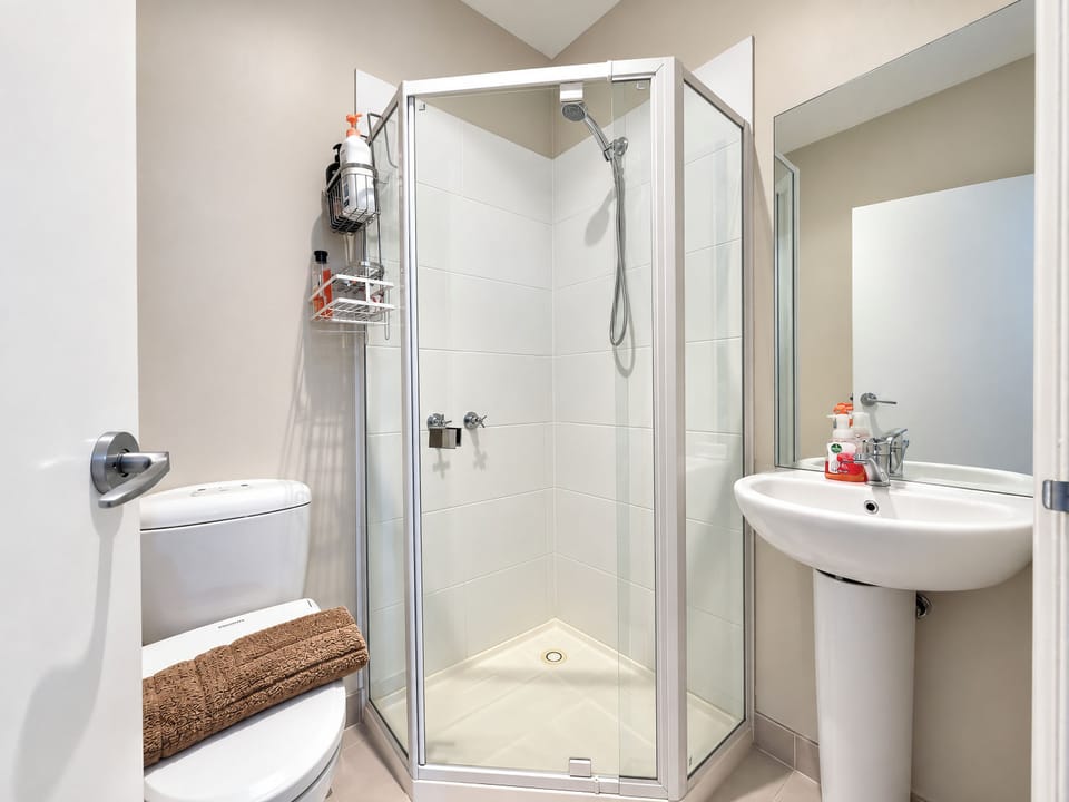 Bright, modern bathroom with glass shower and fresh guest-ready touches