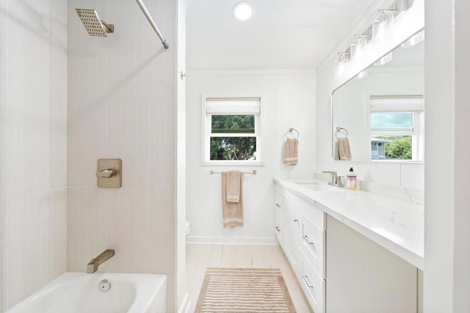 Bathroom by primary bedroom, located in hallway. Newly remodeled with bath tub and shower combination.