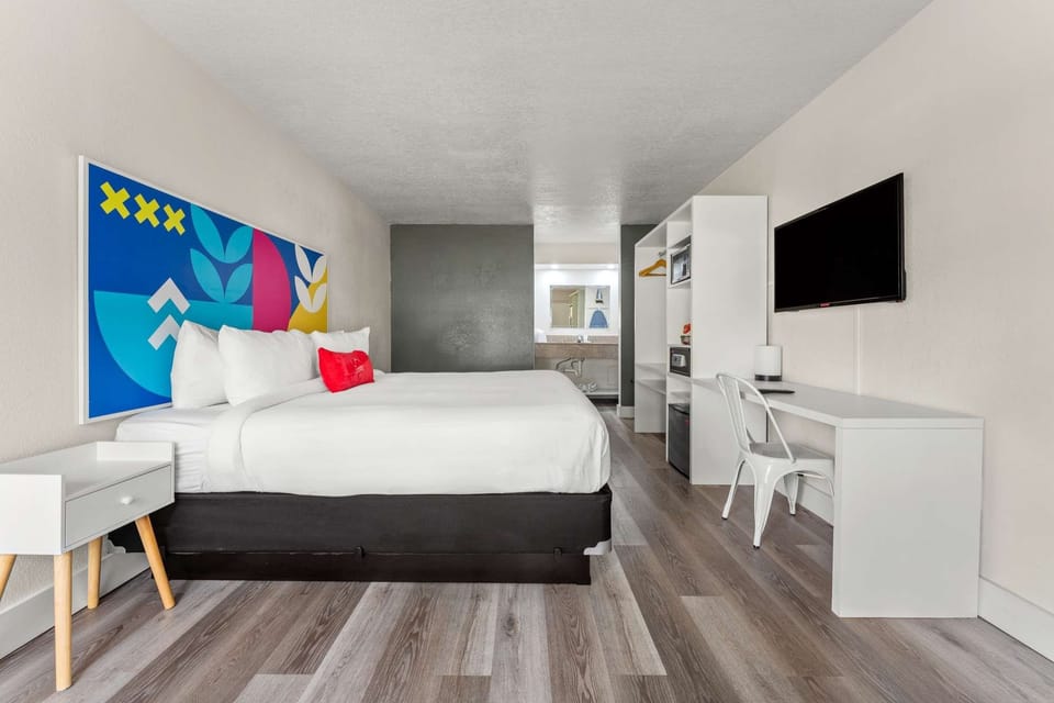 King bed with colorful wall art and open storage space