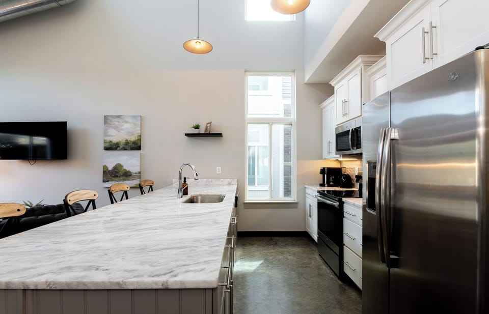 Brewing your morning cup of joe is easy in this bright culinary corner. The sleek stainless steel appliances make cooking feel like a total luxury.