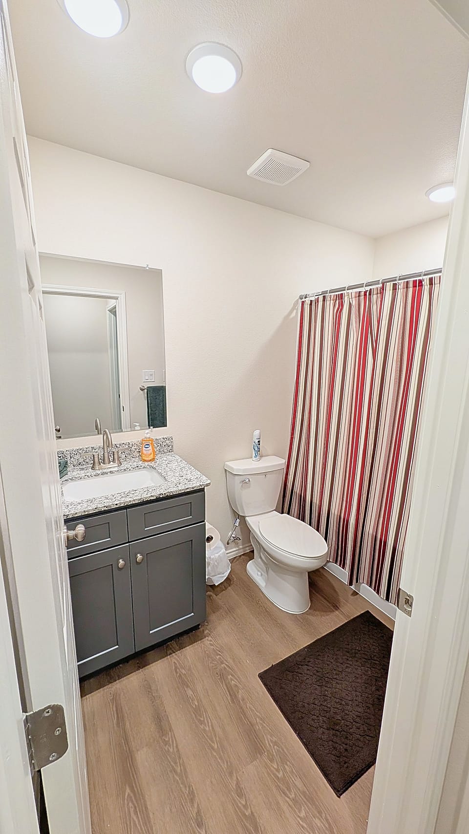 Bright full bathroom with granite vanity and clean modern finishes