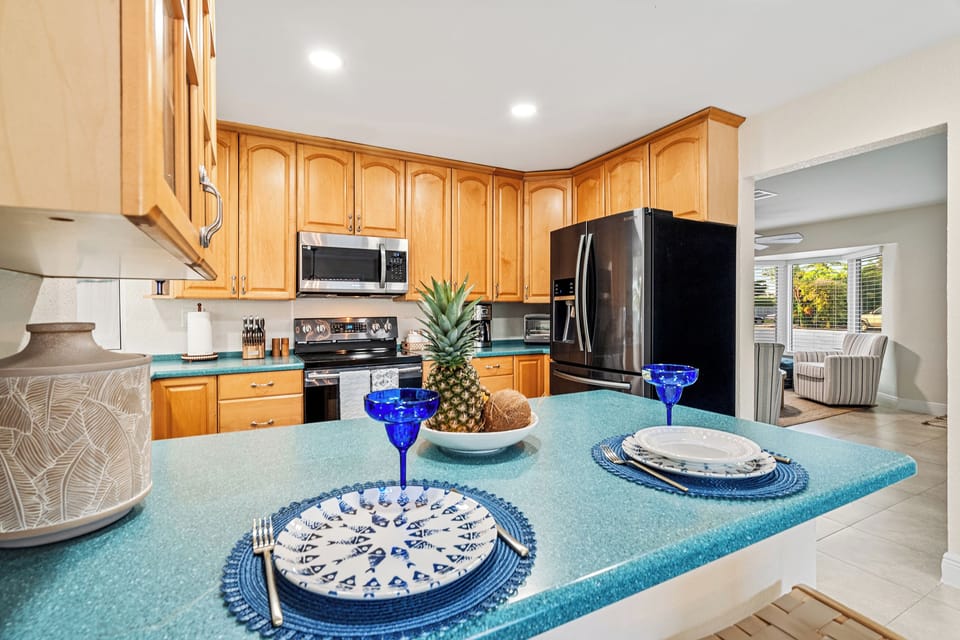 Bright kitchen with large island, stylish place settings, and open layout
