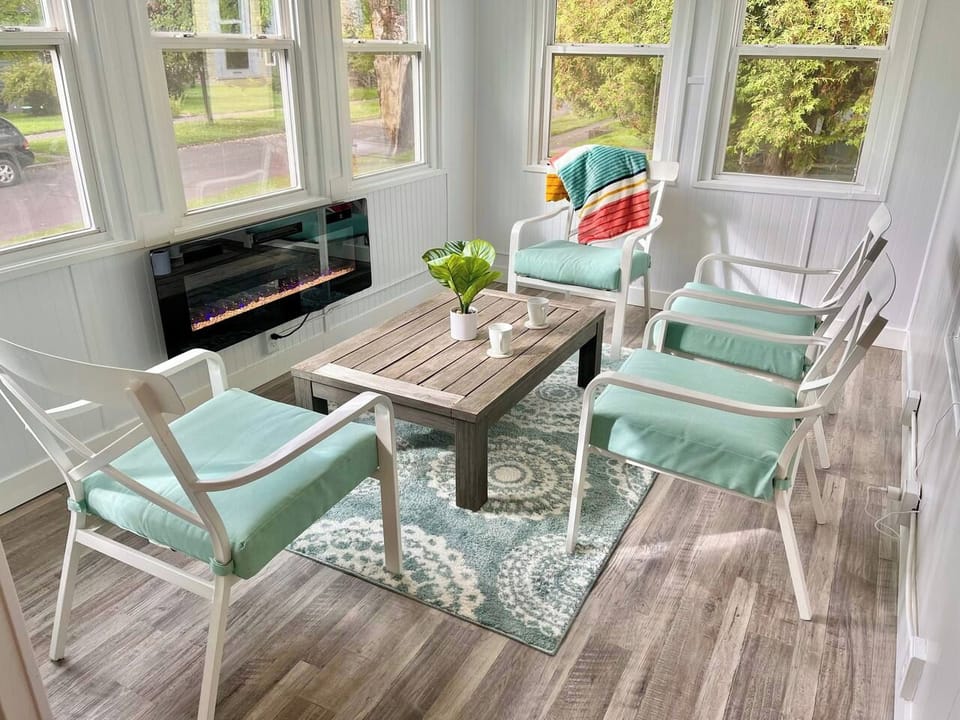 The front porch sun room is a favorite place for morning coffee or curling up with a book by the electric fireplace. 