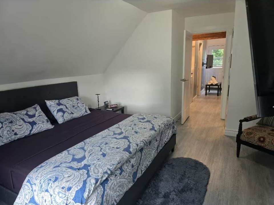 Luxury King Bed with Mounted TV and seating area for comfort.