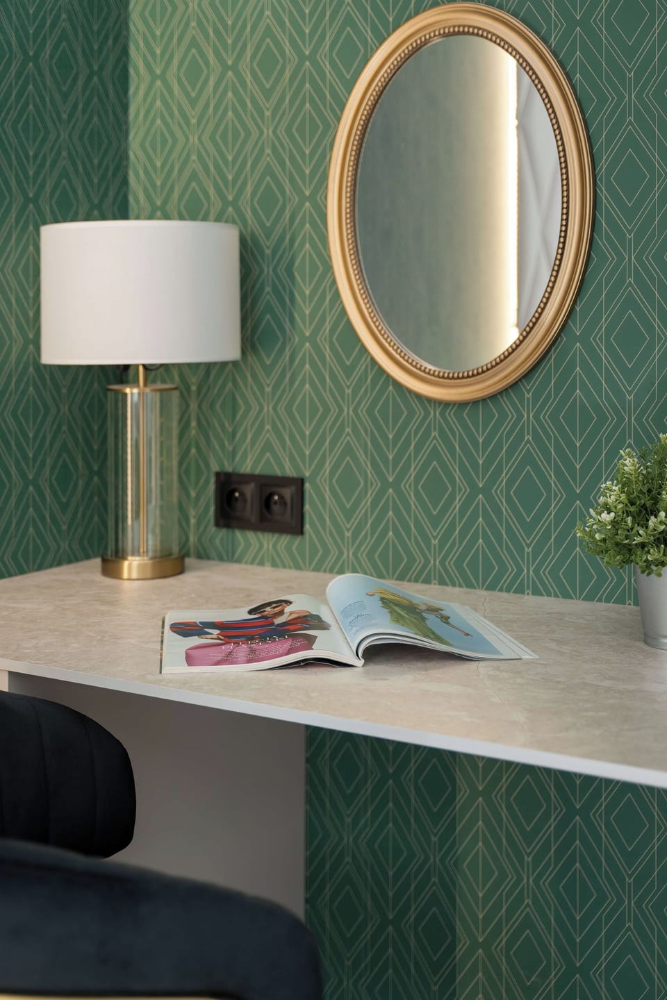 A modern bathroom with a walk-in glass shower, a sink, and dark tiles. Elegant fixtures give the space a luxurious and spa-like feel.