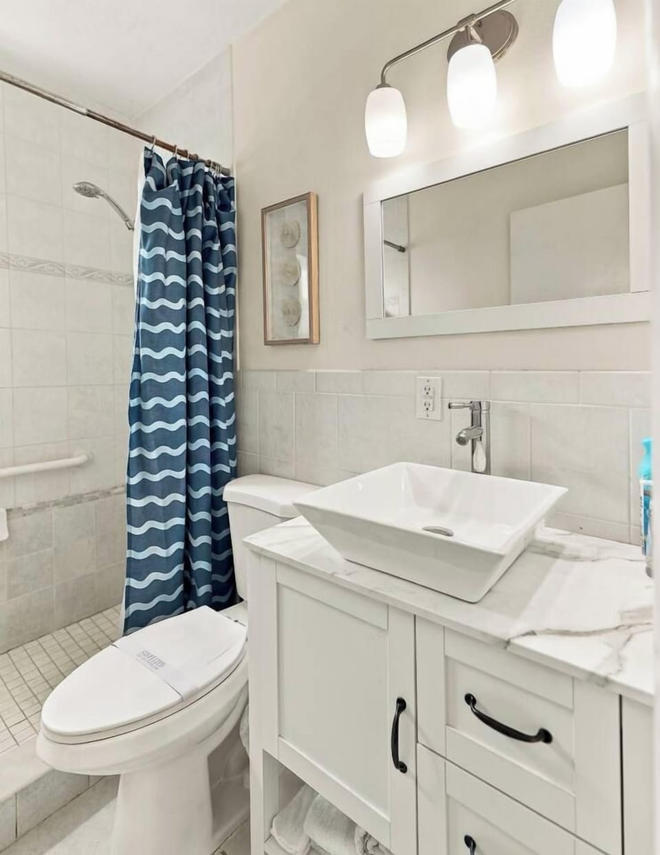Bright updated bathroom with modern vanity and tiled walk-in shower