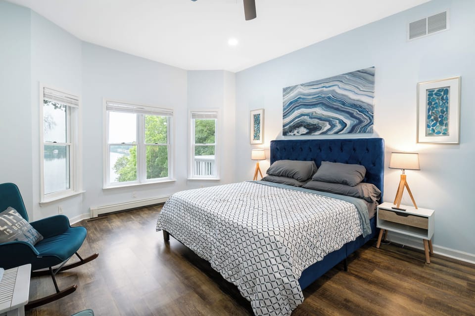 Primary Suite - King bed, velvet headboard and corner windows that put the lake in view before you are out of bed.