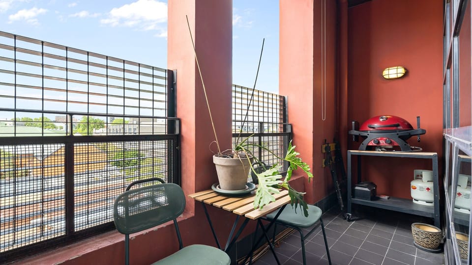 Vibrant apartment balcony with grill.