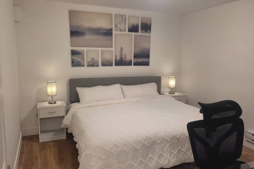 Bright minimalist bedroom with king bed, soft lighting, and modern art