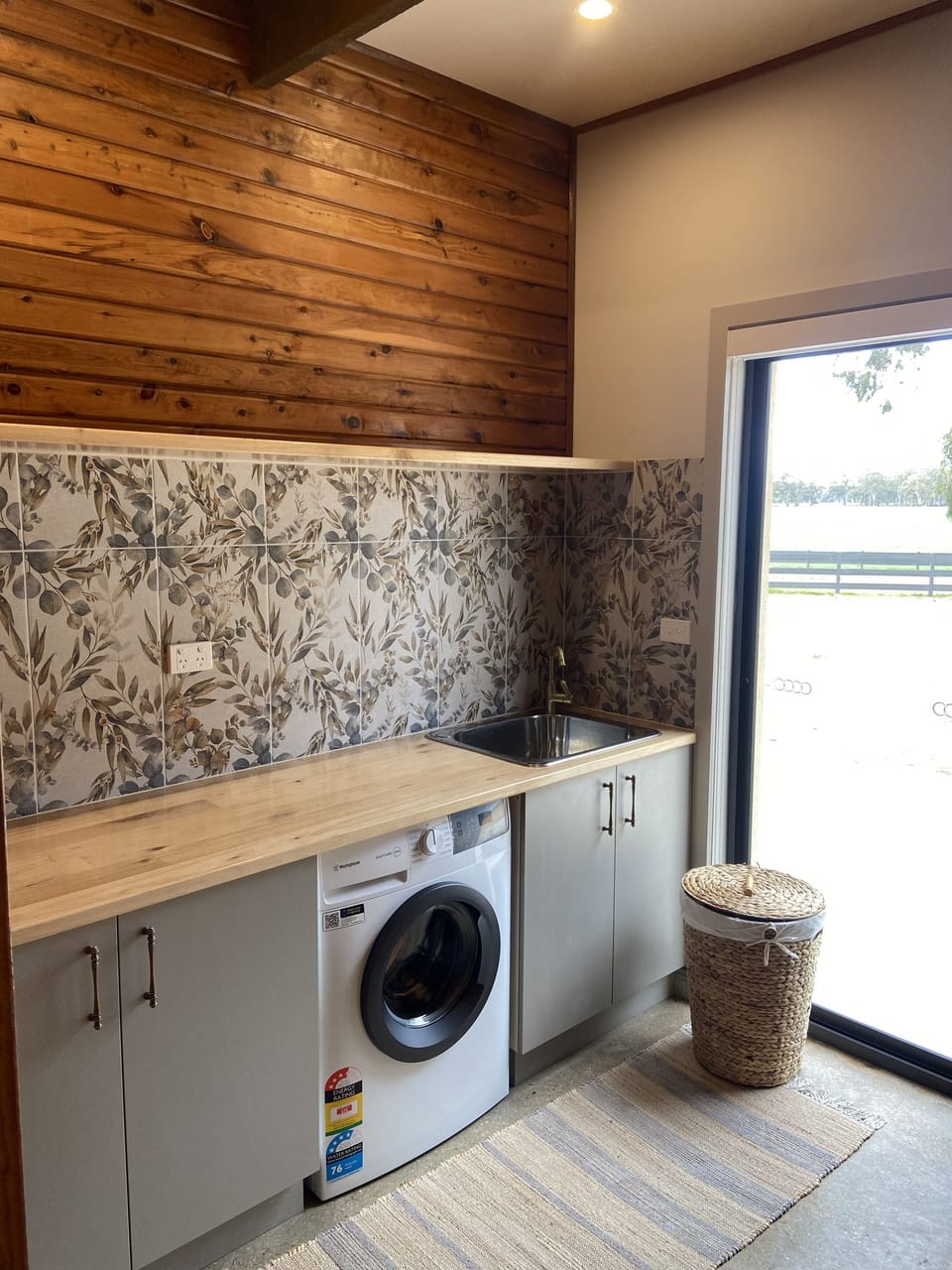 Laundry : A thoughtfully designed laundry combining practical amenities with the warm, rustic character of Bob’s River House.