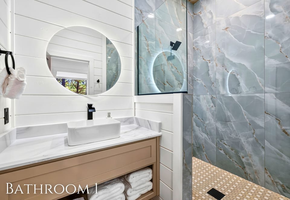 Clean lines and beautiful stonework give this bathroom a fresh, spa-like feel, with a spacious vanity and walk-in shower for an easy start to the day.