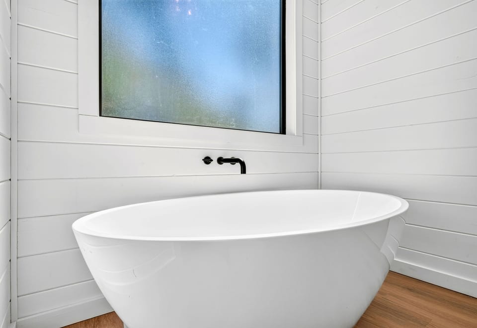 Sink into the freestanding soaking tub when you want a slower moment to yourself, with a clean and calming space designed for unwinding.