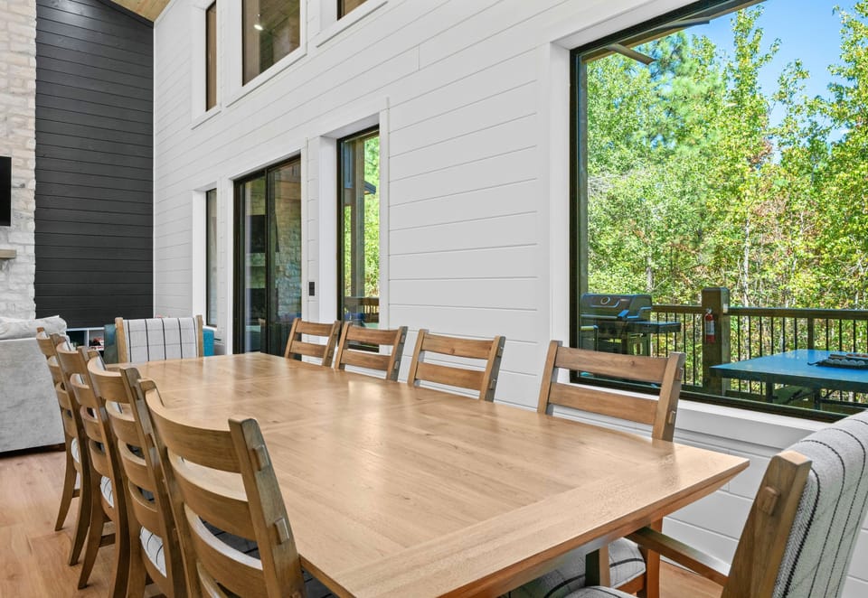 Surrounded by windows and views of the trees, the dining area offers a bright and relaxed setting for sharing meals together.