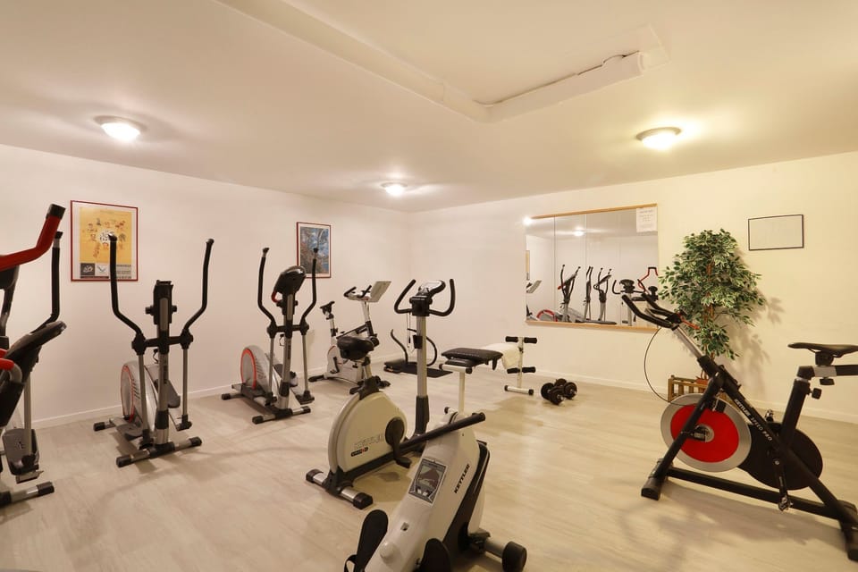 Fitness room with cardio machines and a mirrored wall