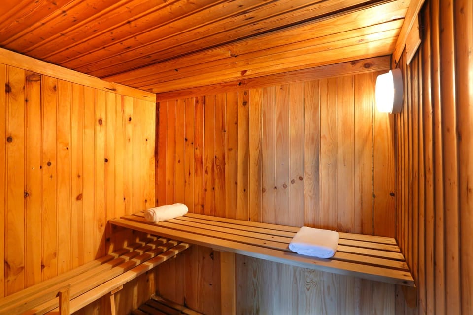Cedar-panelled sauna with two levels of slatted benches