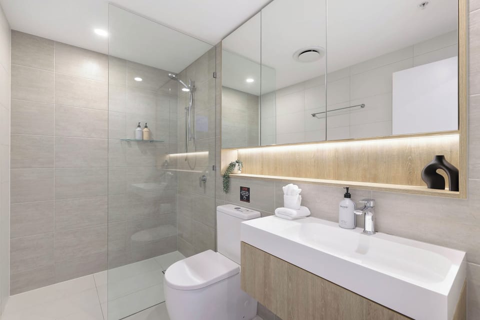 Modern Walk-In Bathroom
Refresh in a sleek, glass-enclosed walk-in shower with a modern floating vanity, soft LED mirror lighting, and complimentary bath amenities.