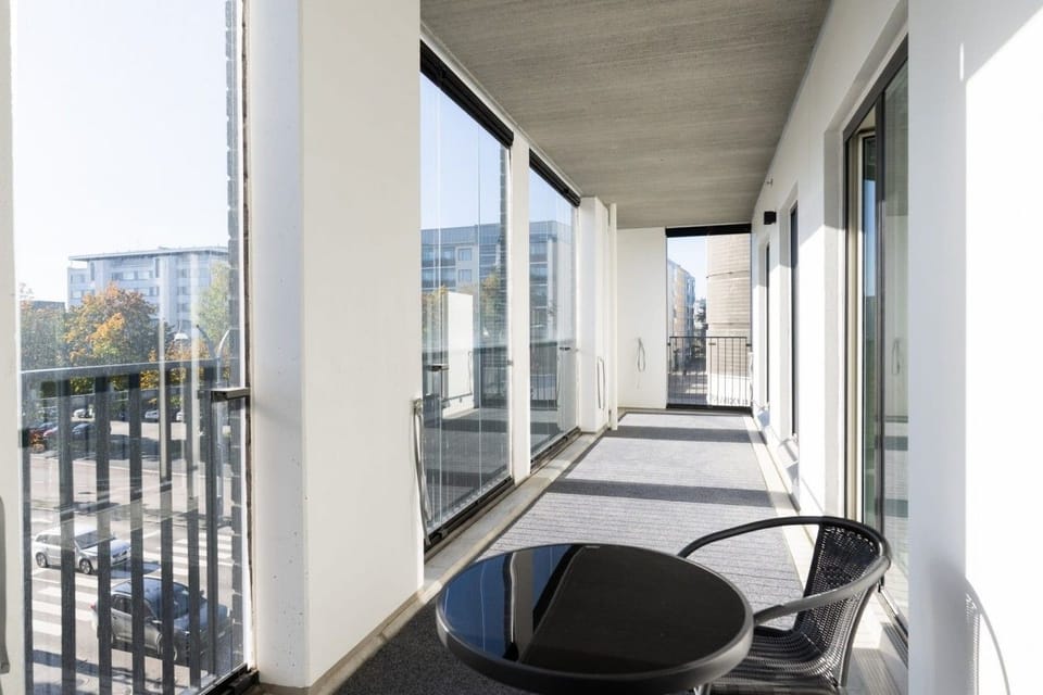 Spacious covered balcony with city views and comfortable seating for relaxing outdoors.