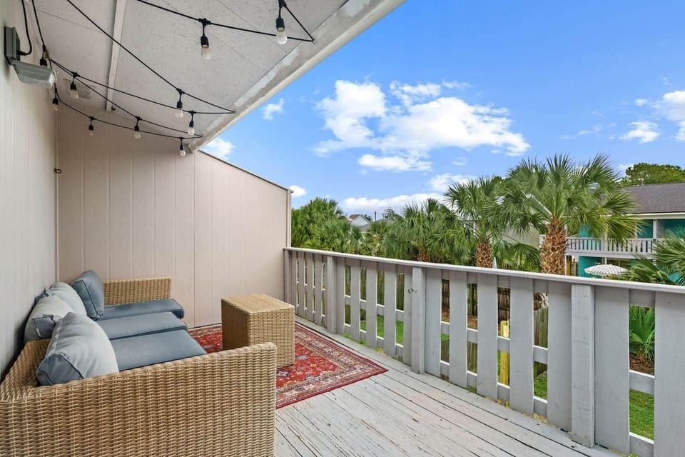 Step from Unit A's king suite onto your covered balcony, furnished with cushioned seating and string lights overlooking the backyard. Enjoy morning coffee or a quiet break, with your bedroom's smart TV and private ensuite just inside