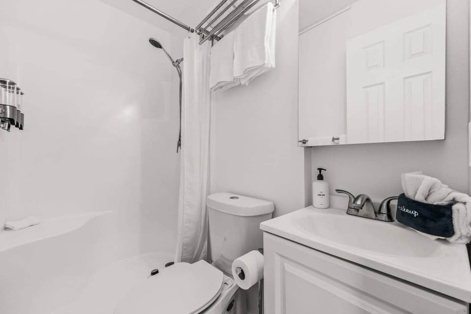 Unit B's private primary bathroom includes a walk-in shower, vanity with storage, and a toilet with a bidet. Towels, shampoo, conditioner, and body wash are provided. This ensuite is accessed from the upstairs king bedroom for added privacy