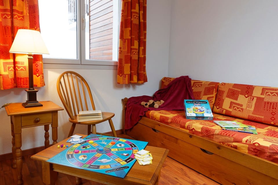 A board game keeps the evening playful beside the trundle sofa bed.