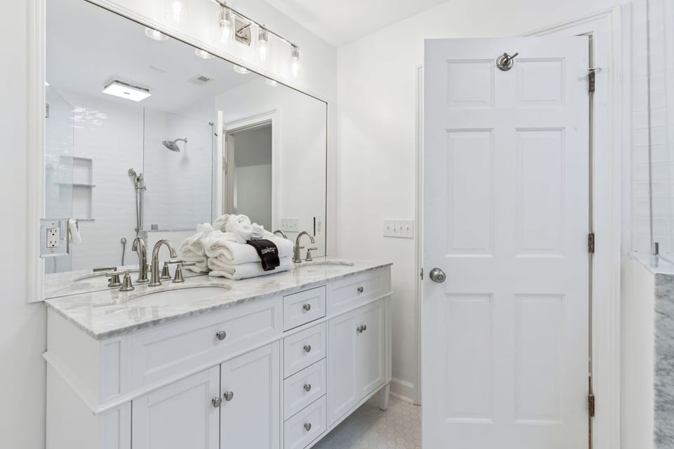 Step into your private spa-like bathroom with elegant marble countertops, dual vanities, and plush rolled towels waiting just for you.