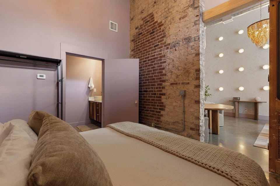 The king bedroom pairs warm modern design with original exposed brick