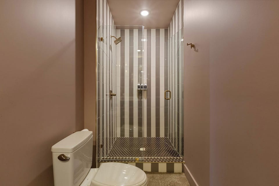 The walk in shower adds a bold design moment to the private ensuite bath