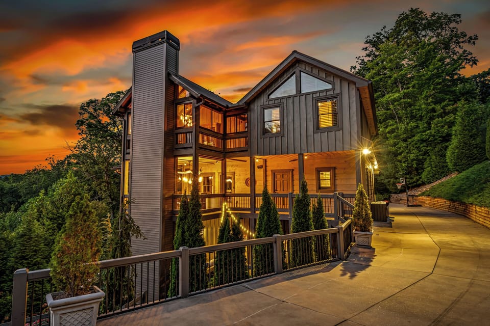 Your Blue Ridge escape begins here. Warm lights, towering trees, and a luxury cabin waiting to welcome you in.