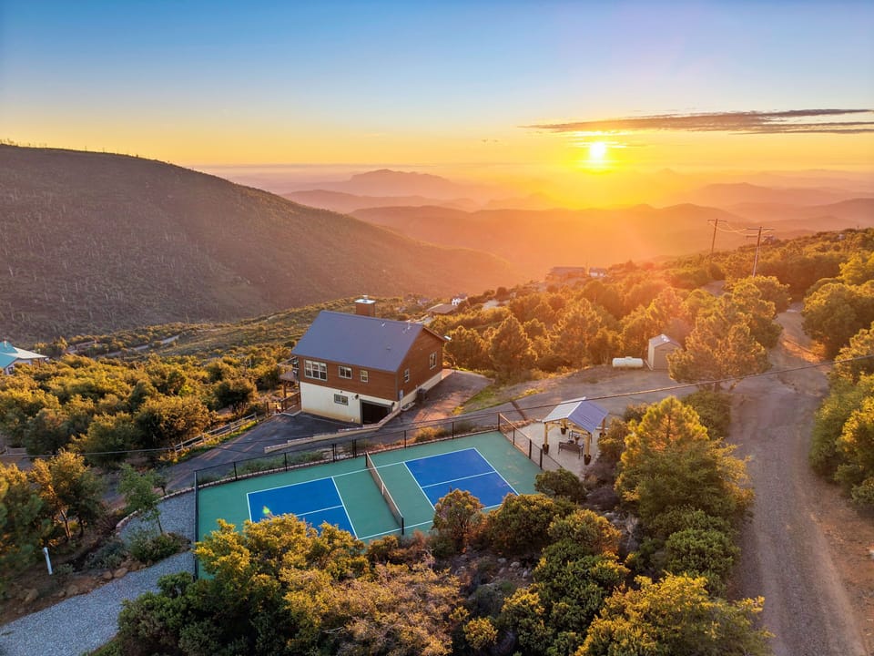 An overhead look at the cabin, private pickleball court, and mountaintop setting.