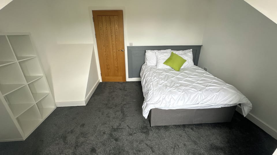 Bright, cozy double bedroom with plush carpet and handy shelving
