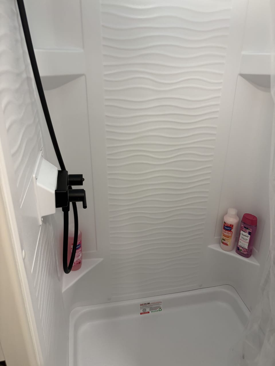 Bright modern shower with sleek white finishes and spa-like textured walls