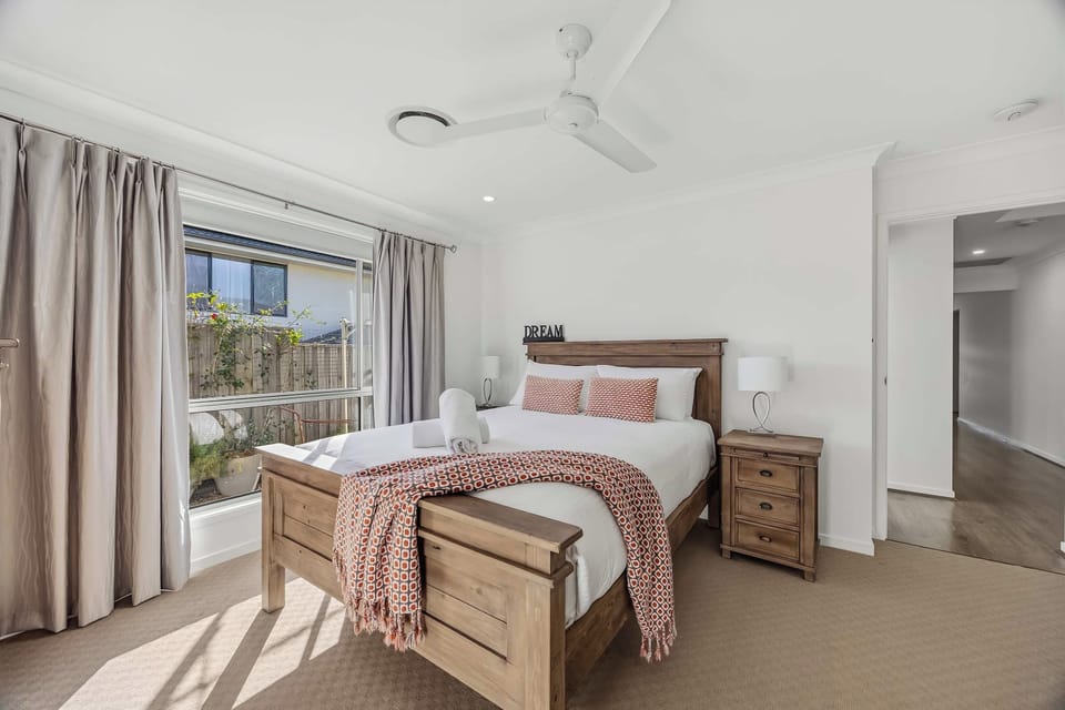 Plush queen size bed, ceiling fan and blockout curtains in master bedroom