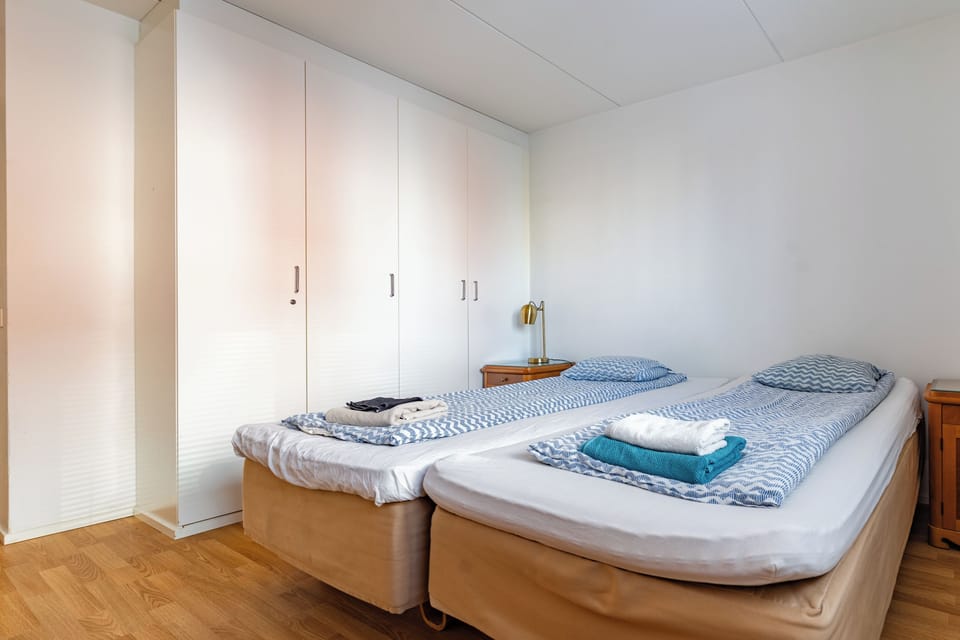 Bright twin bedroom with fresh linens and ample wardrobe space