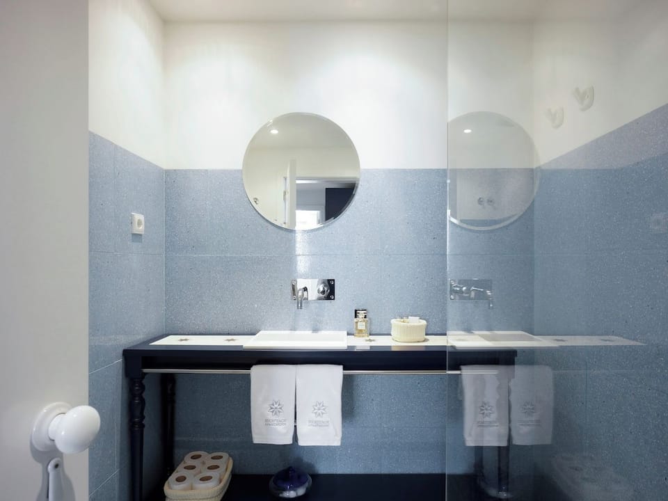 Escape to tranquility in this elegant bathroom, featuring soft blue tiles, modern fixtures, and a sleek double sink. The bright, cozy space ensures a refreshing start to your day. Perfectly designed for comfort and relaxation!