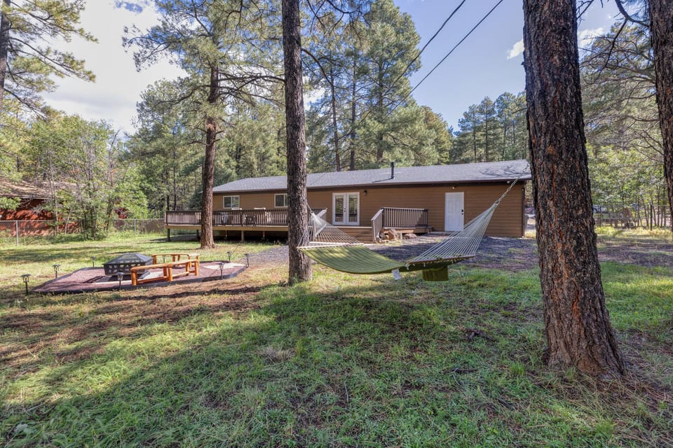 Large backyard surrounded by pines