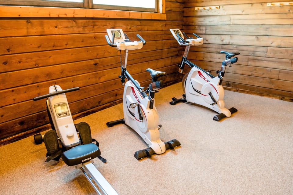 Stationary bikes and a rowing machine fill the wood-panelled fitness room.