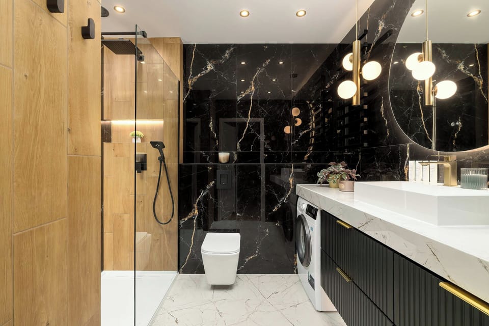 An elegant bathroom showcasing a striking contrast between black marble-style tiles and warm wood-effect surfaces. 