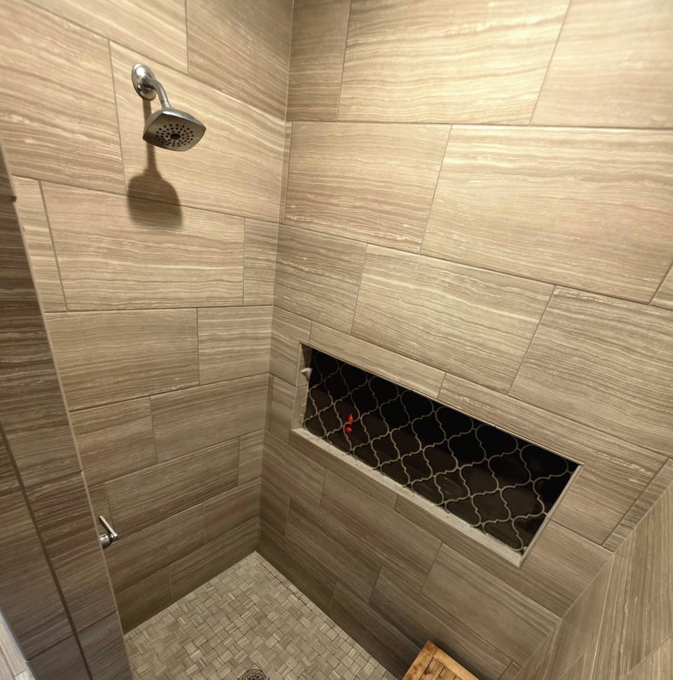 Modern tiled walk-in shower with stylish niche and spa-like design