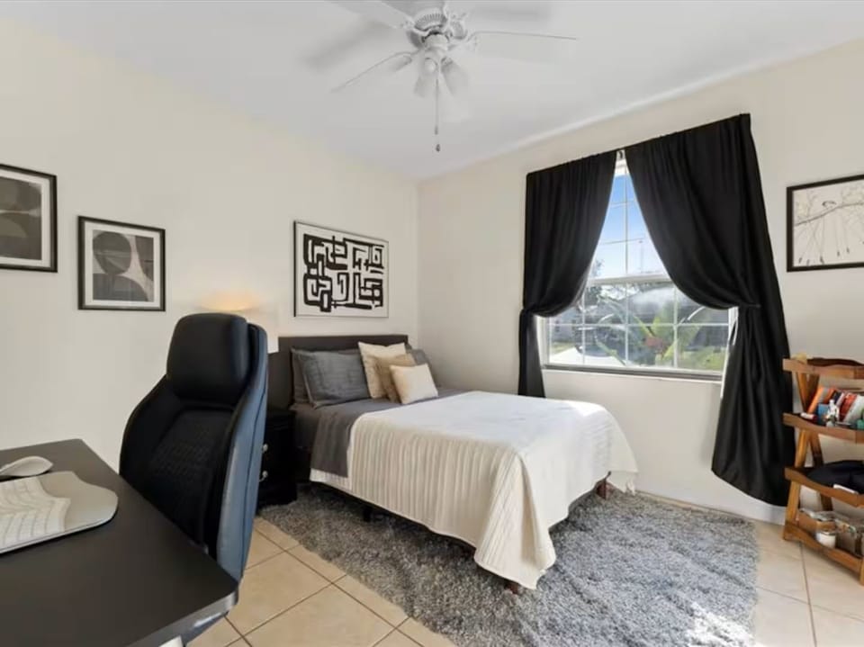 Bright modern bedroom with workspace, natural light, and cozy touches