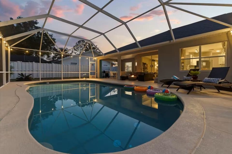 Screened private pool oasis with cozy evening lighting and lounge seating